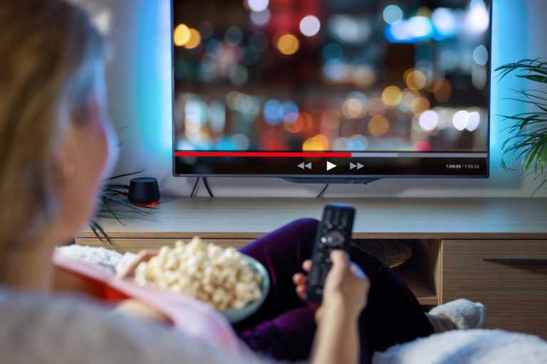 Unleashing the Power of Streaming Ads: Why Your Business Needs Them oman in front of a tv streaming a movie